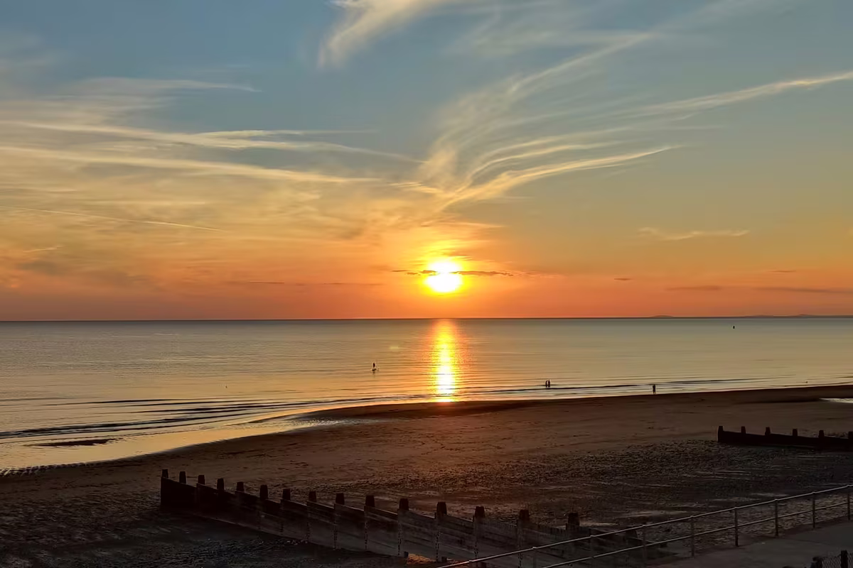 Golden sunset over Tywyn beach and Cardigan Bay from the promenade, Mid-Wales