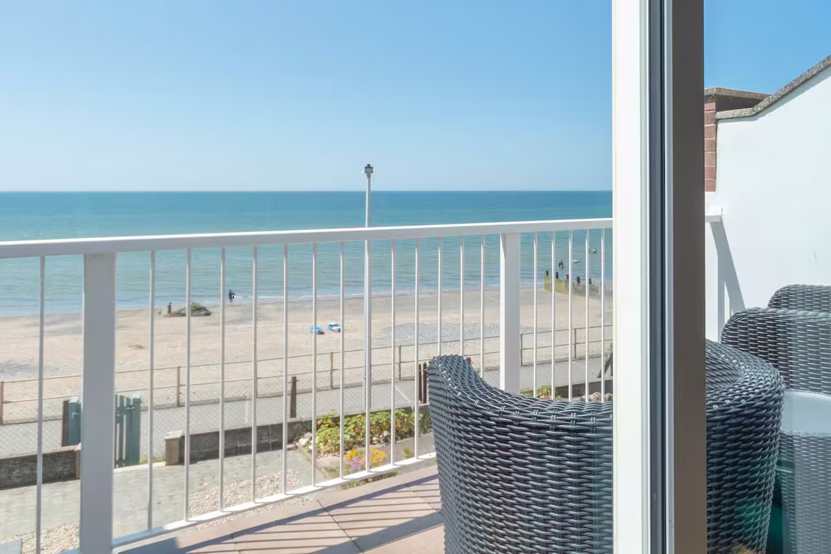 Four Degrees West – private balcony with rattan seating overlooking the beach